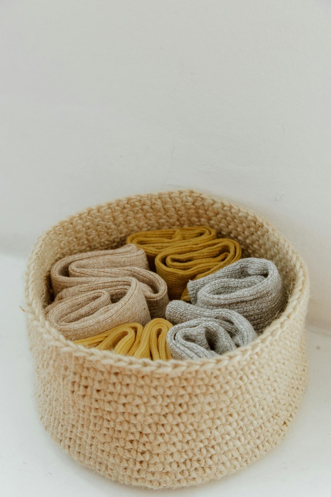 Close-up of rolled socks in a knitted basket, showcasing neat organization and texture.